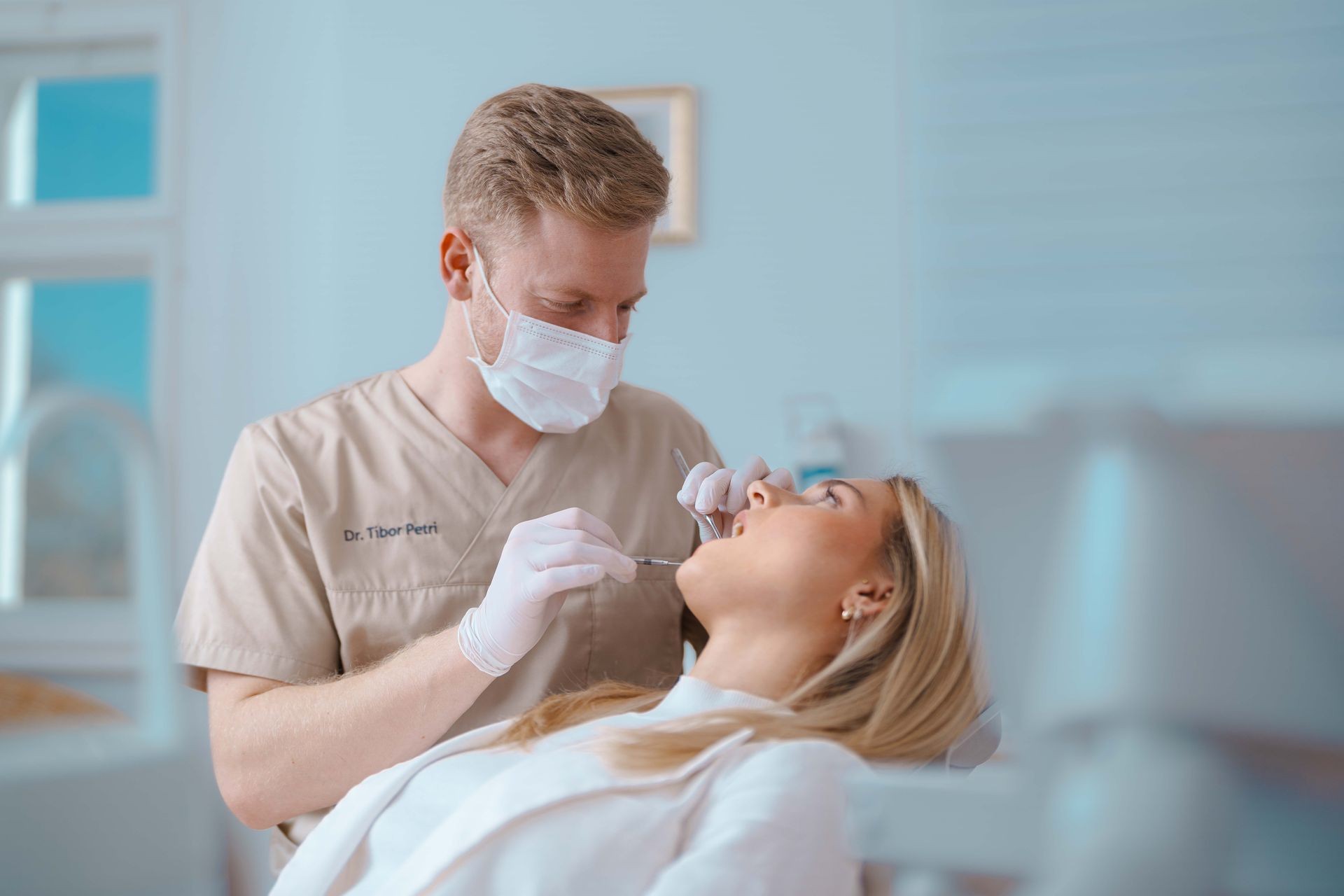 Zahnarzt Dr. Tibor Petri behandelt Patienten im Behandlungsstuhl, mit zahnmedizinischen Instrumenten, helle Klinikumgebung